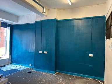 During: Teal wall. During: The side wall painted teal with a section at the top kept white along with the white ceiling. Blue carpet has gone.