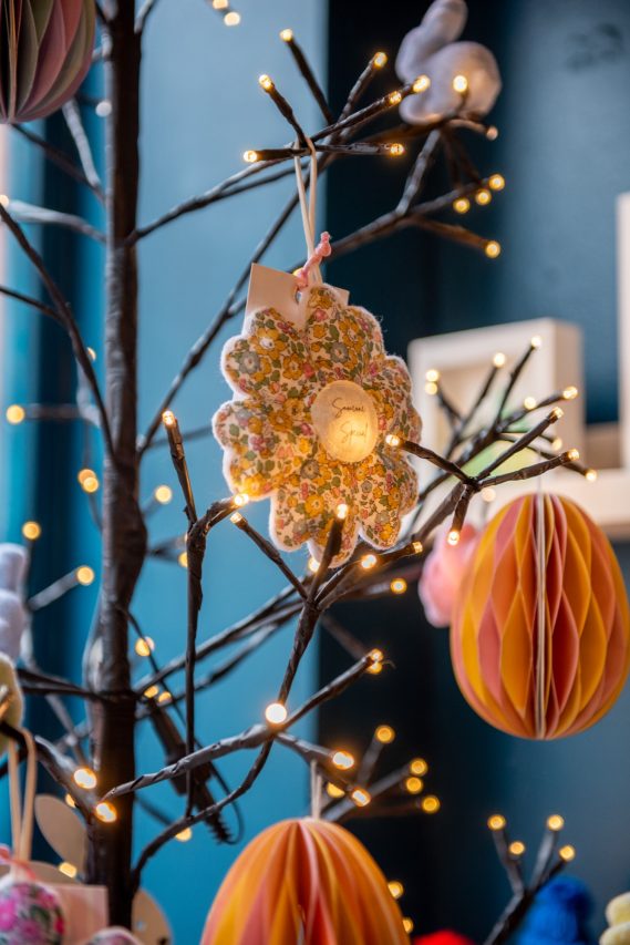 Decorative paper display and handmade gift hanging on a lit up tree.