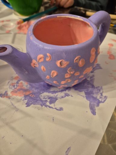 A customer's finished painted teapot. Picture of a customer's finished painted teapot, painted purple with pink dots and pink inside.